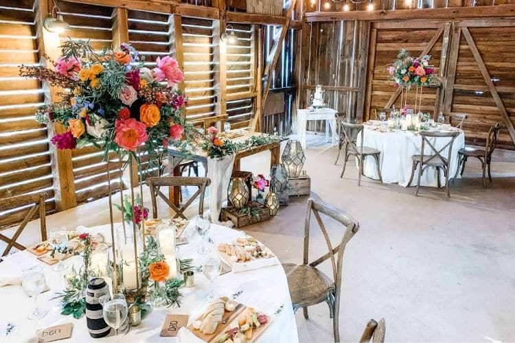 Why Microweddings in Central PA are Trending. Intimate seating at circular tables with floral pink and orange arrangements 